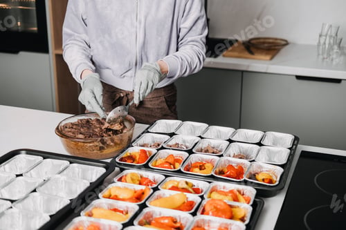 Preview: Meal Prep Service: Portioning Healthy Meat and Vegetables. A meal prep worker portions nutritious