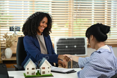 Preview: Real estate agent handshaking with a couple of customers. Property purchase concept