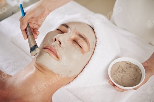 Preview: Cosmetologist applying purifying clay mask