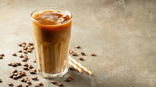 Preview: Ice coffee in a tall glass with cream poured over and coffee beans.