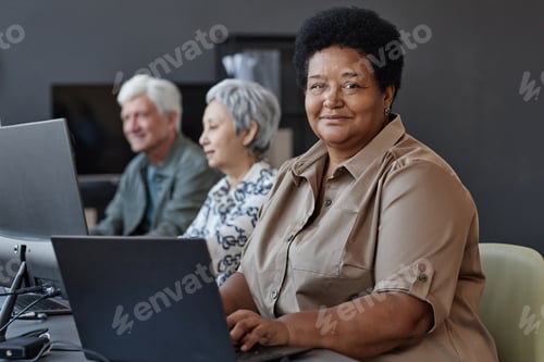 Preview: Black senior woman in computer class for elderly smiling at camera