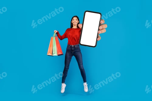 Preview: Woman Holding Smart Phone With Blank Screen and Shopping Bags