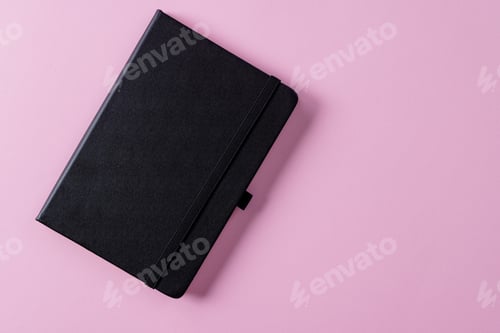 Preview: Close up of black notebook with copy space on pink background