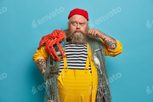 Preview: Strict serious bearded sailor curls mustache frowns eyebrows and looks directly at camera poses with