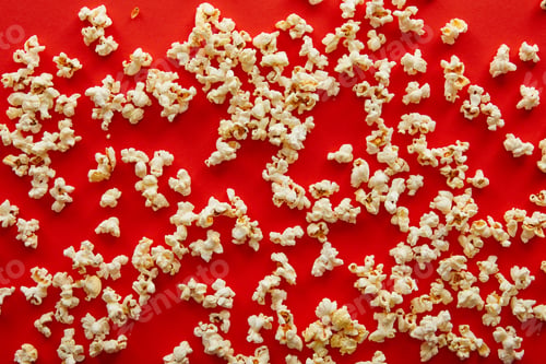 Preview: top view of fresh popcorn scattered on red background