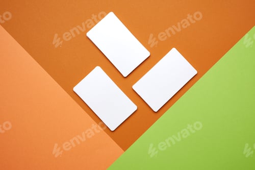 Preview: Piles of white paper blank business cards on orange-green background