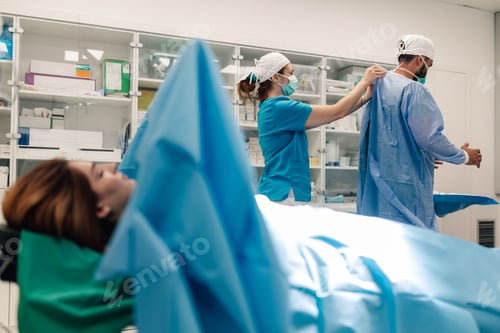 Preview: Medical team prepping for surgery in operating room setting.