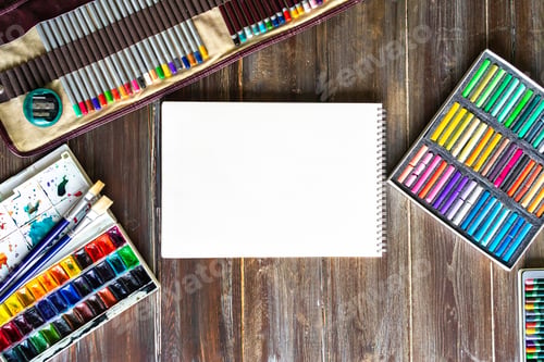 Preview: Flat lay art workplace, pencils, brushes, watercolor paints, paper and crayon pastel chalks
