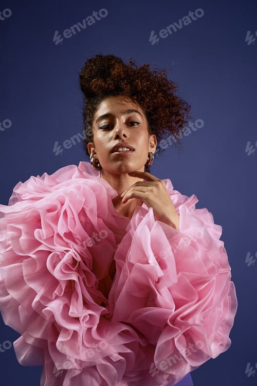 Preview: Young Woman Smiling Softly Wearing Ruffled Fabric in Studio