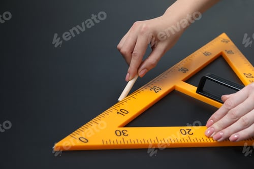 Preview: Woman drawing with chalk and triangle ruler on blackboard, closeup. Space for text