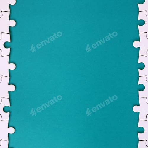 Preview: Fragment of a folded white jigsaw puzzle on the background of a blue plastic surface