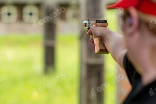 Preview: A determined female athlete, known for her precision and skill in sports shooting, aims her rifle