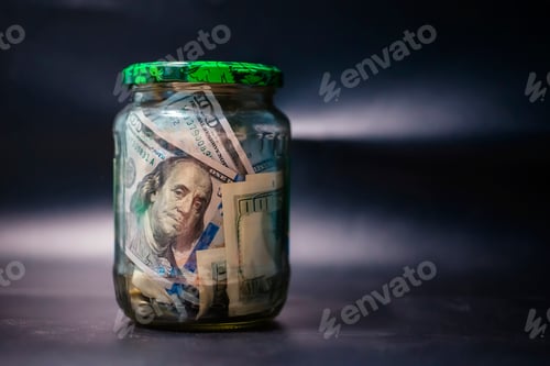 Preview: Dollars in a glass jar on a black background. Money