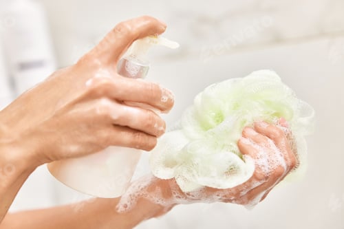 Preview: female hands pouring liquid soap shower gel from bottle on sponge