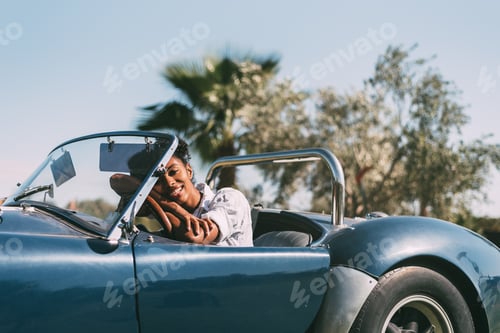 Preview: Black woman driving a vintage convertible car
