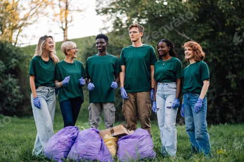 Preview: Group of volunteers collecting garbage in park posing for photo