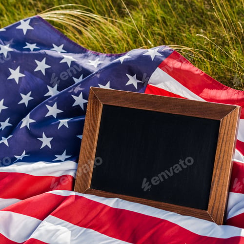 Preview: close up of empty chalkboard on american flag with stars and stripes