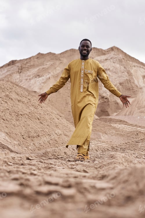 Preview: African American Man in Traditional Clothing Walking Towards Camera in Desert
