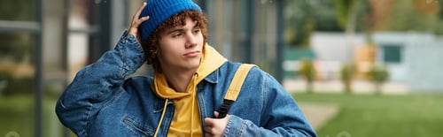 Preview: Curly teenager enjoys a cool autumn day in a denim jacket and blue beanie hat