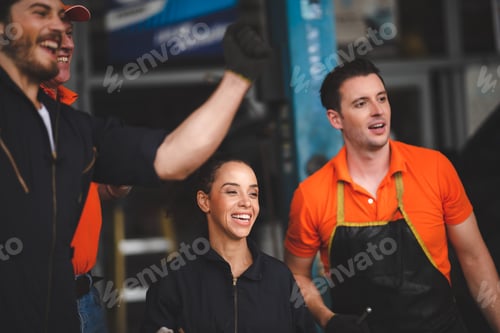 Preview: young and senior male and female car mechanics wearing uniform enjoying and celebrating