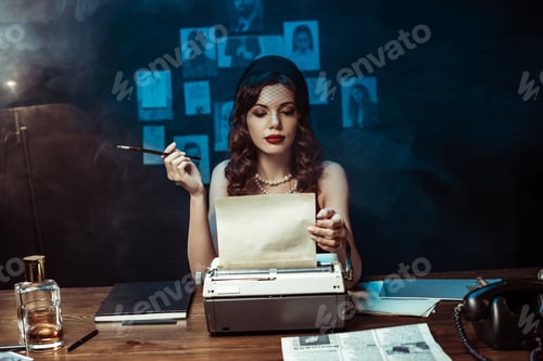 Preview: Pensive woman with mouthpiece using typewriter in dark office