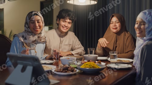 Preview: Happy Asian muslim family celebrate long distance with cousin video call online Ramadan dinner.