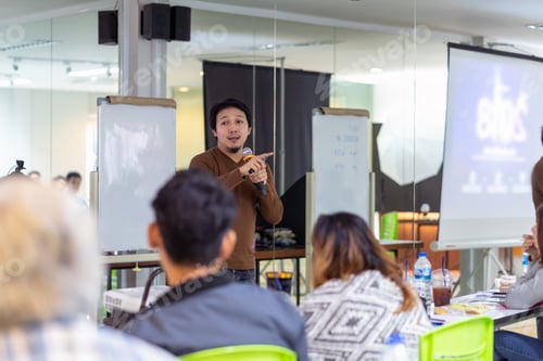 Preview: Asian Speaker or lecture with casual suit on the stage in front of the room presenting