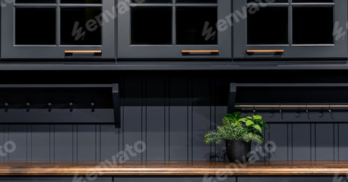 Preview: Modern dark kitchen cabinets with wooden countertop. Elegant furniture with gold handles and plant.