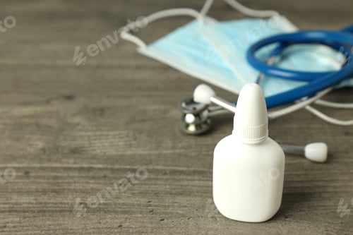 Preview: Nasal spray, medical mask and stethoscope on gray textured background