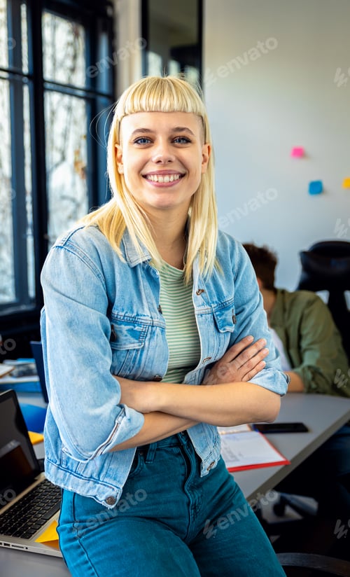 Preview: Portrait of young woman standing in office looking at camera.