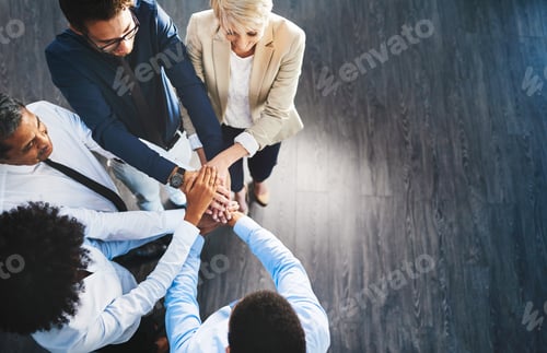 Preview: Shot of a group of businesspeople joining their hands together in unity in an office