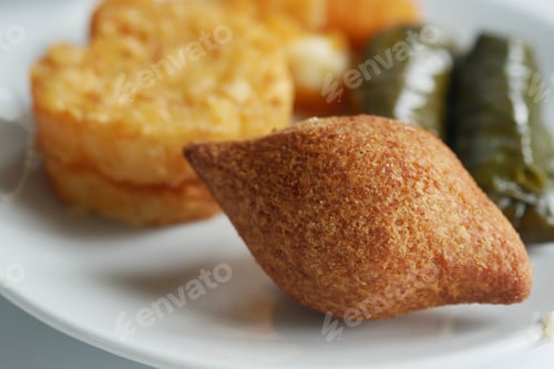 Preview: Savory pastries and stuffed vegetables on a white plate