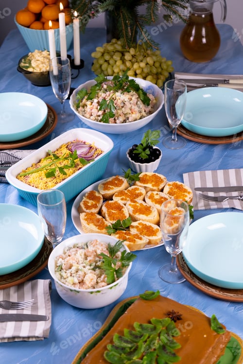 Preview: Festive table. Christmas food. Salads, sandwiches with red caviar. Feast. Dishes and tablecloth are