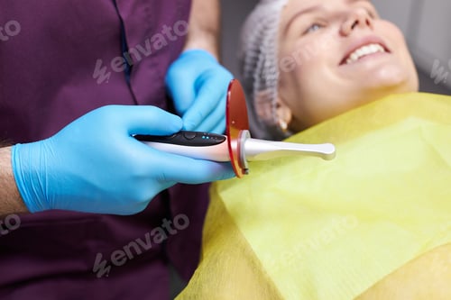 Preview: Selective focus on modern dental equipment- an ultraviolet lamp for tooth filling in dentist's hand