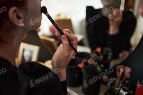 Preview: Caucasian Teen Girl Applying Makeup While Sitting at Vanity Mirror Indoors