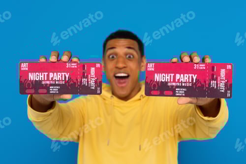 Preview: smiling african american man showing concert tickets in hands isolated on blue