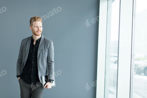 Preview: Young man with tablet by the wall