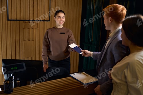 Preview: Young female administrator registers guests at the reception desk