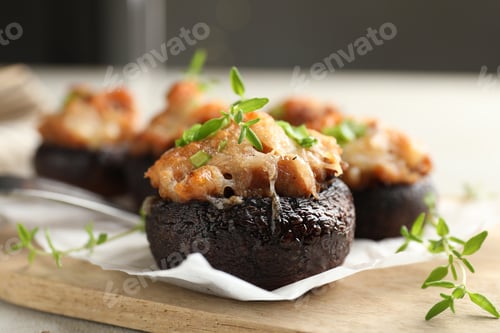Preview: Tasty stuffed mushrooms served on light table against blurred background, closeup
