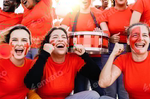 Preview: Crazy football fans celebrating in the crowd while watching the game at sport stadium