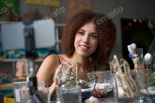 Preview: Cheerful female florist posing at her beautiful workplace