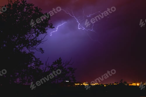 Preview: Rays in a night storm with light and clouds.