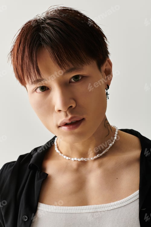 Preview: Stylish young Asian man shows confidence in modern urban setting with trendy accessories