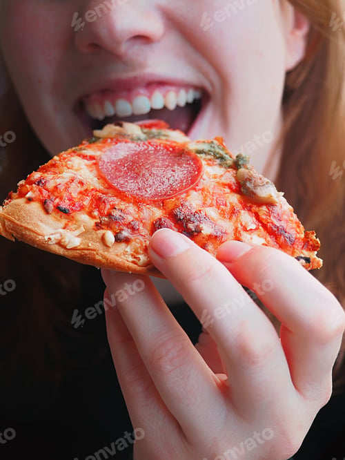 Preview: Woman eating a slice of pizza