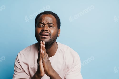Preview: Black bristle man crying while holding his palms together