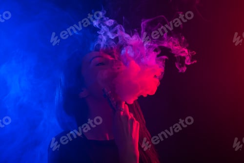 Preview: Young woman smoking vape or e-cigarette in neon light