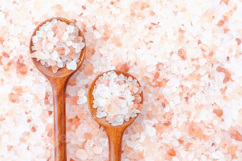 Preview: Two wooden spoons with pink himalayan salt close-up, copy space.