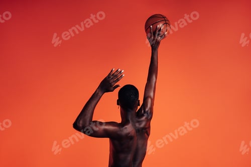 Preview: Back view of unrecognizable African American male athlete throwing basket ball