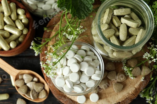 Preview: Concept of herbal medicine pills on wooden table, top view