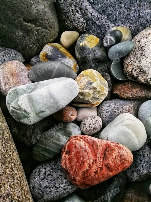 Preview: Closeup vertical shot of a pile of colorful pebble stones on a Molen beach in Norway